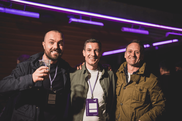 Three attendees posing for a photo at the Converge after-party.